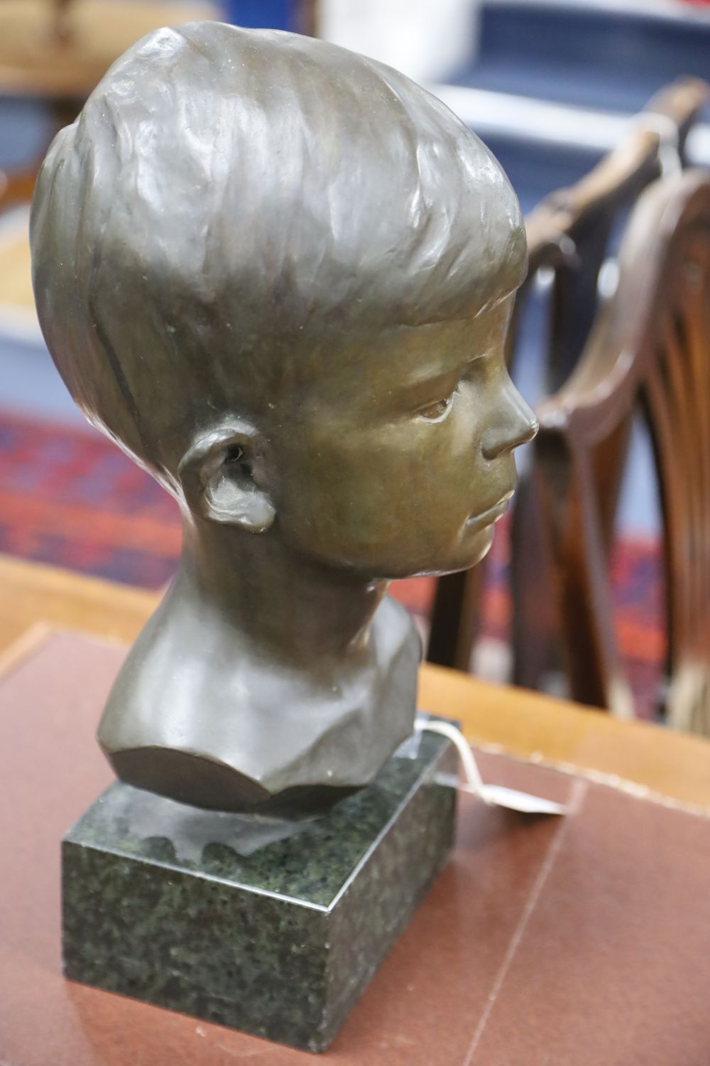 A bronze bust of a boy, signed R.Swann 1930, on marble base, height 38cm, some scuffing to the nose shows some white metal although we